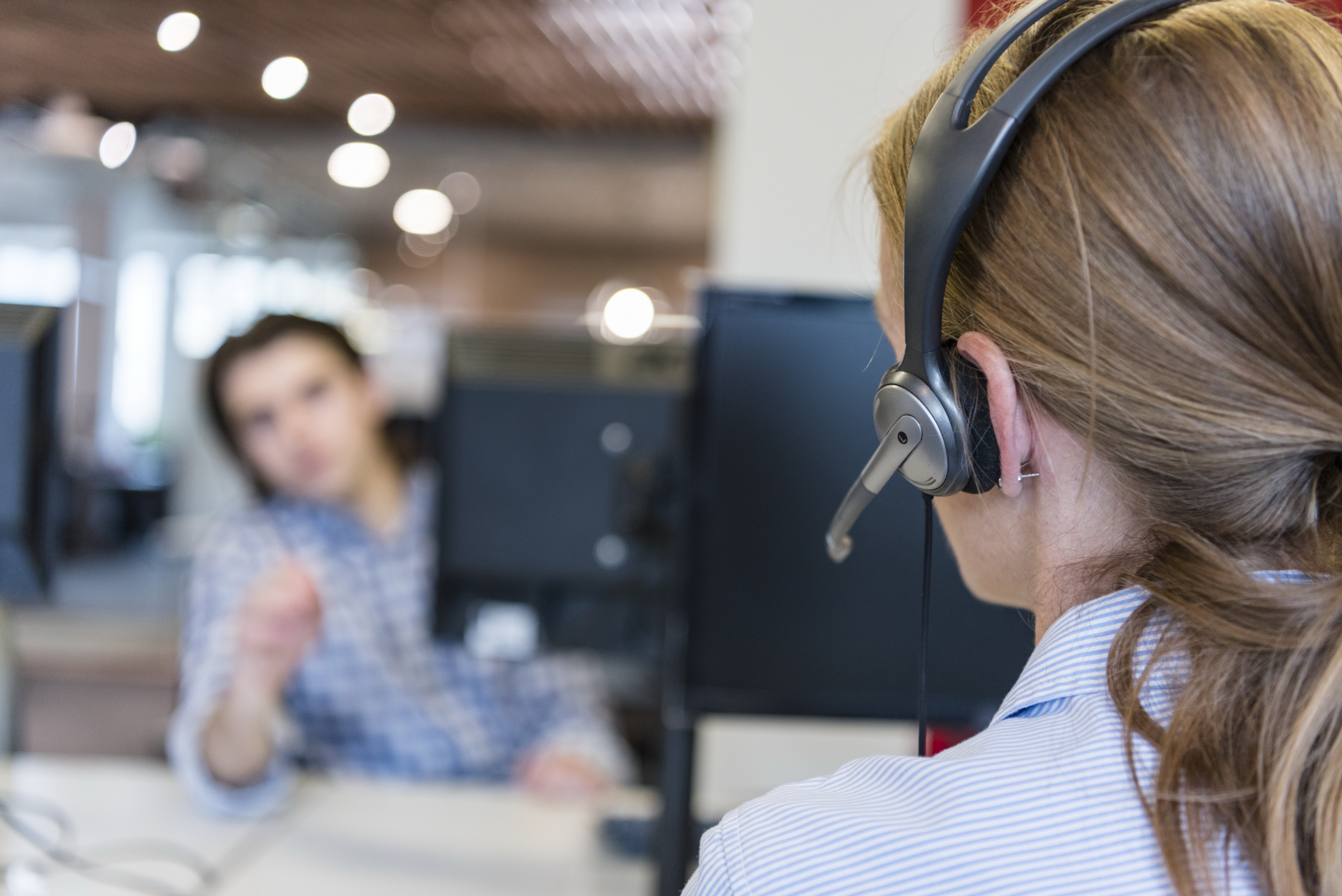 female customer support phone operator with headset  at workplace