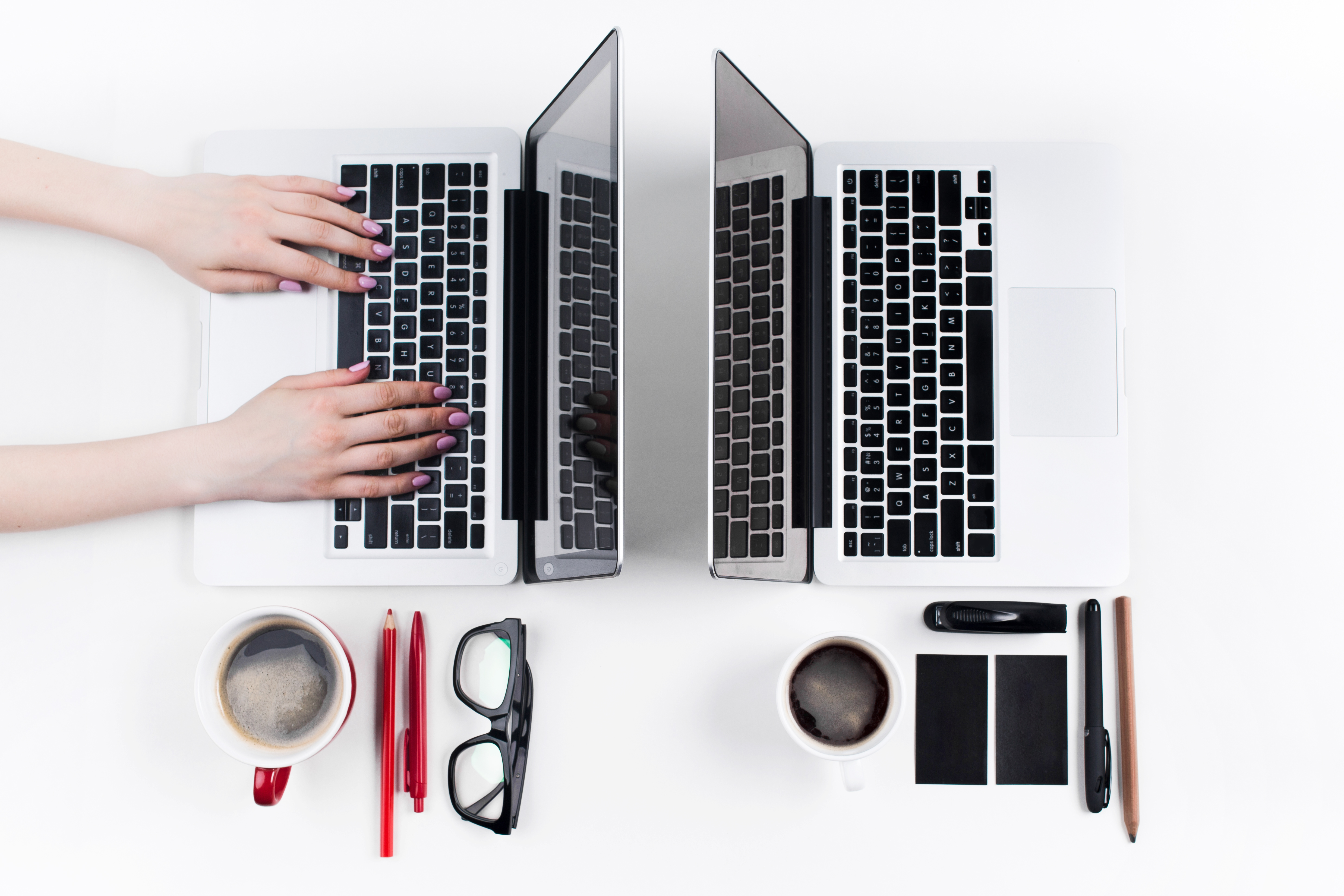 Hands of people working in the office on the white desk. Concept of comfortable male and female workplaces.